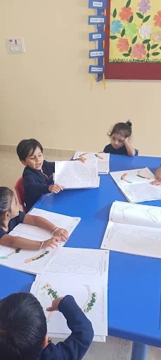 Students colouring worksheets at classroom table