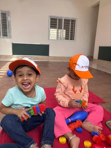 Toddlers playing with toys on a mat