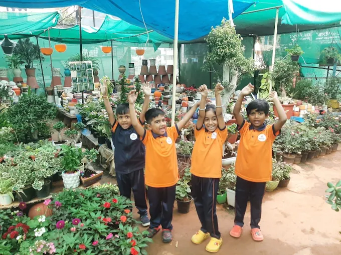 Children cheering in an outdoor garden nursery